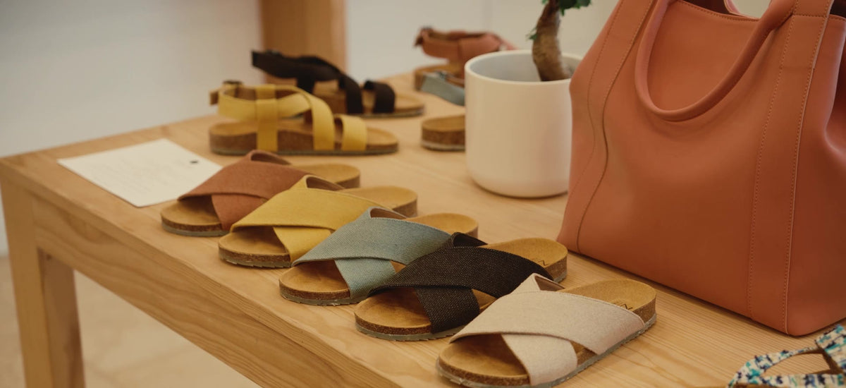 Sandálias Zouri em várias cores numa mesa de madeira